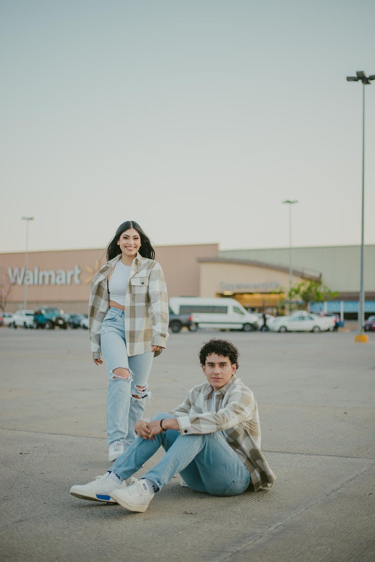 Couple wearing matching shirts posing in Walmart parking lot.